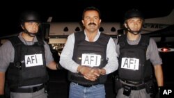 Mexican authorities escort accused drug cartel leader Caro-Quintero, Dec. 20, 2001, at an airport in Sinaloa, Mexico. 