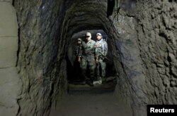 FILE - Afghan Special Forces members inspect a cave that was used by suspected Islamic State militants in Achin district, Nangarhar province, Afghanistan, April 23, 2017.