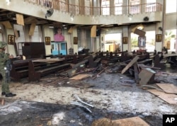 A soldier views the inside of the Roman Catholic cathedral in Jolo, the capital of Sulu province in the southern Philippines, after two bombs exploded, Jan. 27, 2019, in this photo provided by WESMINCOM Armed Forces of the Philippines.