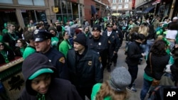 FILE - Cleveland police walk with pedestrians as they patrol downtown, March 17, 2016. City officials say they are prepared for “challenges” during the Republican Convention.