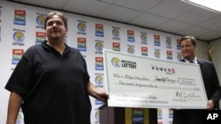 Donald Lawson holds his ceremonial check with Michigan Lottery Commissioner M. Scott Bowen at a news conference at the Michigan Lottery headquarters in Lansing, Michigan, August 31, 2012. 