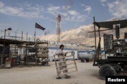 FILE - An Iranian laborer works at a unit of South Pars Gas field in Asalouyeh Seaport, north of Persian Gulf, Iran, Nov. 19, 2015. Due to sanctions relief, Iranian industries like oil and air travel have resumed international business.