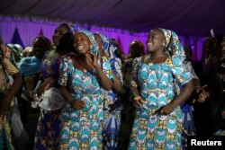 Some of the 106 girls who were kidnapped by Boko Haram militants in the Nigerian town of Chibok, are seen dancing joyfully during the send-forth dinner in Abuja, Nigeria, Sept. 13, 2017.