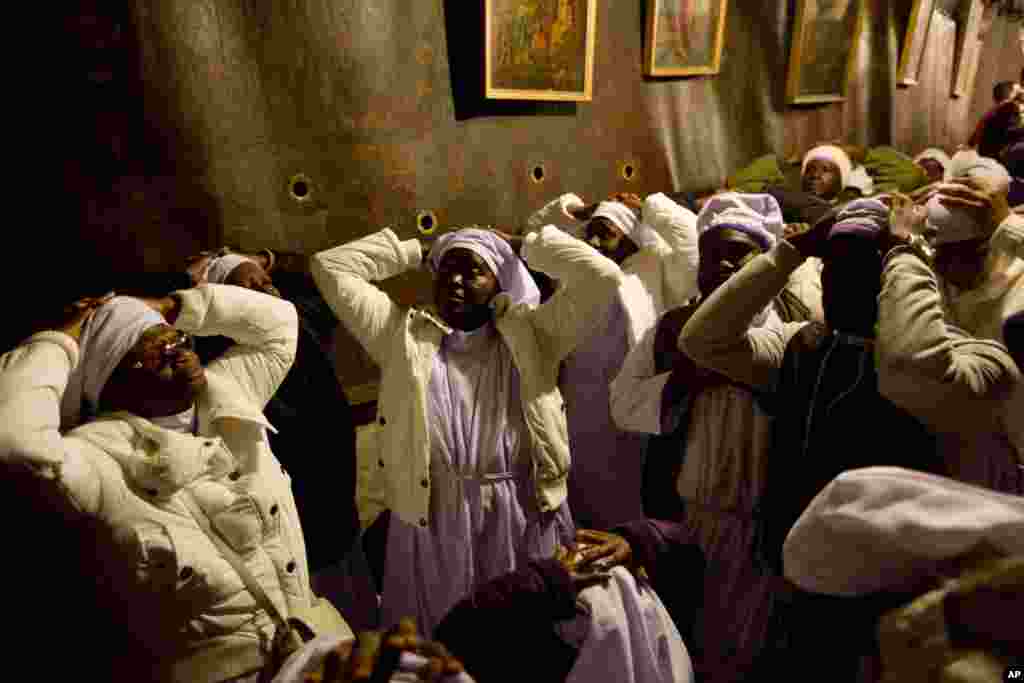 Christian pilgrims from Nigeria pray inside the Grotto of the Church of the Nativity, traditionally believed by Christians to be the birthplace of Jesus Christ, in the West Bank city of Bethlehem on Christmas Eve.