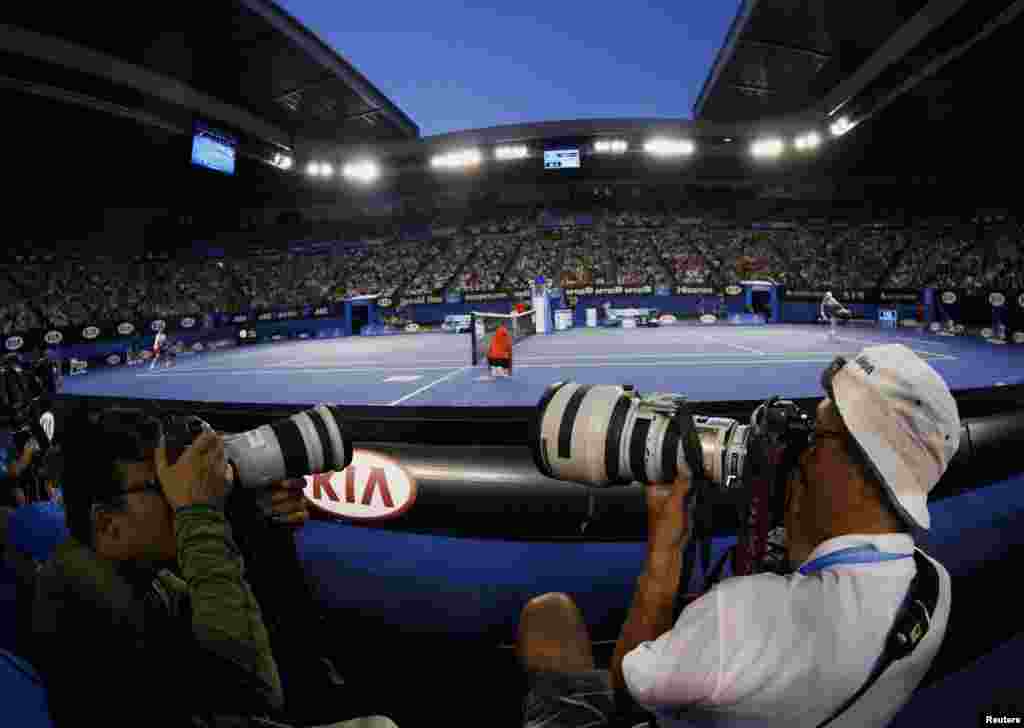 Para juru foto mengabadikan pertandingan tenis antara petenis Ceko Tomas Berdych (kiri) melawan petenis Swiss Stanislas Wawrinka pada semifinal turnamen grand-slam Australia Terbuka di Melbourne.