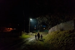 After a long working day Dr. Viktoria Mahnych and her two daughters walk to her parents to celebrate an eve of the Orthodox Christmas in Iltsi village, Ivano-Frankivsk region of Western Ukraine, Wednesday, Jan. 6, 2021. (AP Evgeniy Maloletka)