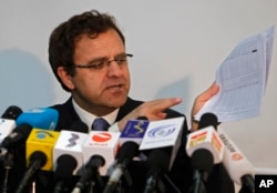 Afghan Finance Minister Hazrat Omar Zakhilwal shows documents during a news conference in Kabul, Aug. 7, 2012.