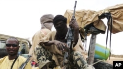 Militiamen from the Ansar Dine Islamic group sit on a vehicle in Gao in northeastern Mali, June 18, 2012. 
