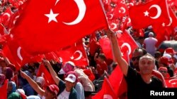 A man waves Turkey's national flag during the Democracy and Martyrs Rally, organized by Turkish President Tayyip Erdogan and supported by ruling AK Party (AKP), opposition Republican People's Party (CHP) and Nationalist Movement Party (MHP), to protest against last month's failed military coup attempt, in Istanbul, Turkey, August 7, 2016. 