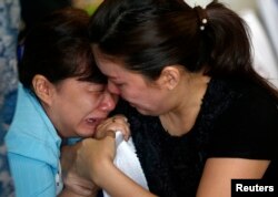 Family members of passengers onboard missing AirAsia flight QZ8501 cry at a waiting area in Juanda International Airport, Surabaya, December 29, 2014.