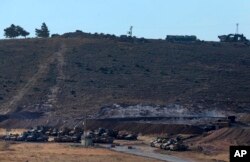 Turkey's forces' tanks and vehicles hold positions close to the border with Syria, near the town of Reyhanli, Oct. 9, 2017.