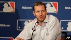 FILE - Two-time Cy Young Award winner Roy Halladay answers questions after announcing his retirement after 16 seasons in the major leagues with Toronto and Philadelphia at the MLB winter meetings in Lake Buena Vista, Fla., Dec. 9, 2013. 