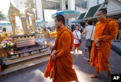 Thai Buddhist monks arrive at the Erawan Shrine at Rajprasong intersection in Bangkok, Thailand, Wednesday, Aug. 19, 2015.