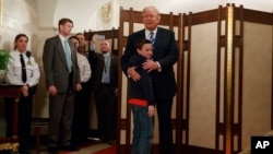 El presidente Trump abraza al niño Jack Cornish, el primero en la línea de visitantes de la Casa Blanca al reiniciarse los tours de la mansión ejecutiva.