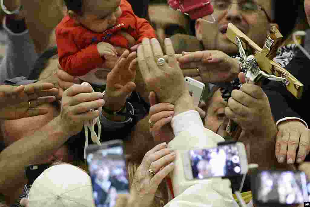 Faithful reach for Pope Francis&#39; hand, center, during an audience with Roma, Sinti and others itinerant group members, at the Vatican.