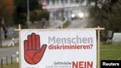 A poster reading: "Discrimination against people? No to COVID restriction tightening" is seen before Swiss voters decide about the federal government's pandemic response plan in a binding referendum, near Oberwil-Lieli in Switzerland, Nov.16, 2021. 