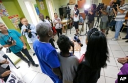 A Haitian family that did not want to be identified, living in the U.S. with Temporary Protected Status (TPS) speaks to members of the media, May 22, 2017, in Miami.