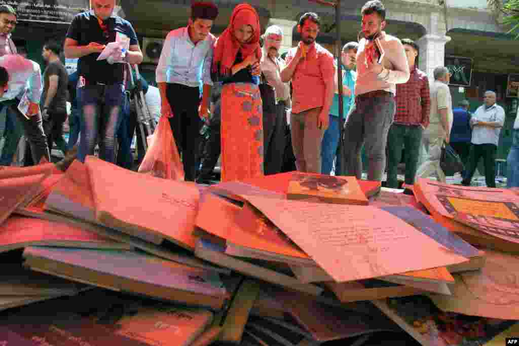 Iraqis buy books at an open-air market in the Baghdad to donate them to the University of Mosul&#39;s library, as part of an initiative to replenish the institution after its documents were destroyed by Islamic State fighters when they took the city.