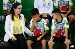 Rescued soccer player "Titan" Chanin Vibulrungruang reacts after paying respect to a portrait of Saman Gunan