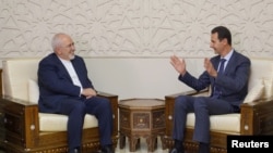 Presiden Suriah Bashar al-Assad (kanan) bertemu dengan Menteri Luar Negeri Iran Mohammad Javad Zarif di Damaskus, Suriah, 3 September 2018. 