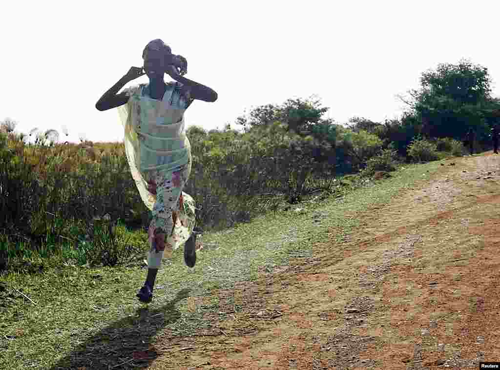 A woman runs along a road during an air strike by the Sudanese air force in Rubkona near Bentiu, South Sudan, April 23, 2012. (Reuters)