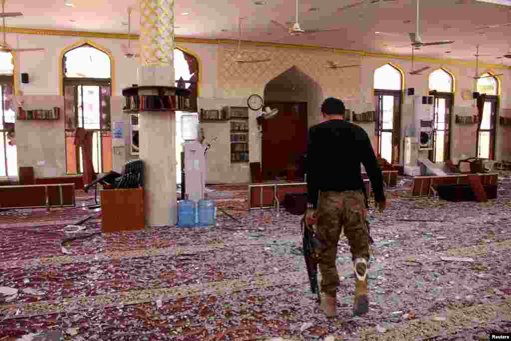 A member of security forces organized by the Saudi-led coalition inspects a mosque damaged in a suicide car bomb attack outside a police forces camp in Aden, Yemen, Nov. 14, 2017.