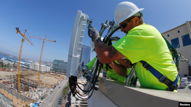 电信工人为AT&T在美国加利福尼亚州圣地亚哥市中心的5G无线网络安装了一个由爱立信制造的5G天线系统。(2019年4月23日)