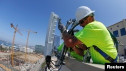 资料图片：美国工人2019年4月在加州安装爱立信的5G设备。