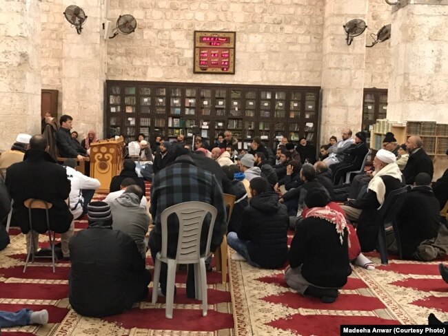 مرد حضرات نماز ِفجر کے بعد عالم ِدین کے گرد گھیرا ڈالے ہوئے