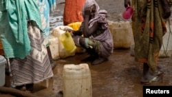 A woman waits in queue to collect water at Yusuf Batil refugee camp, Upper Nile, South Sudan, July 4, 2012.