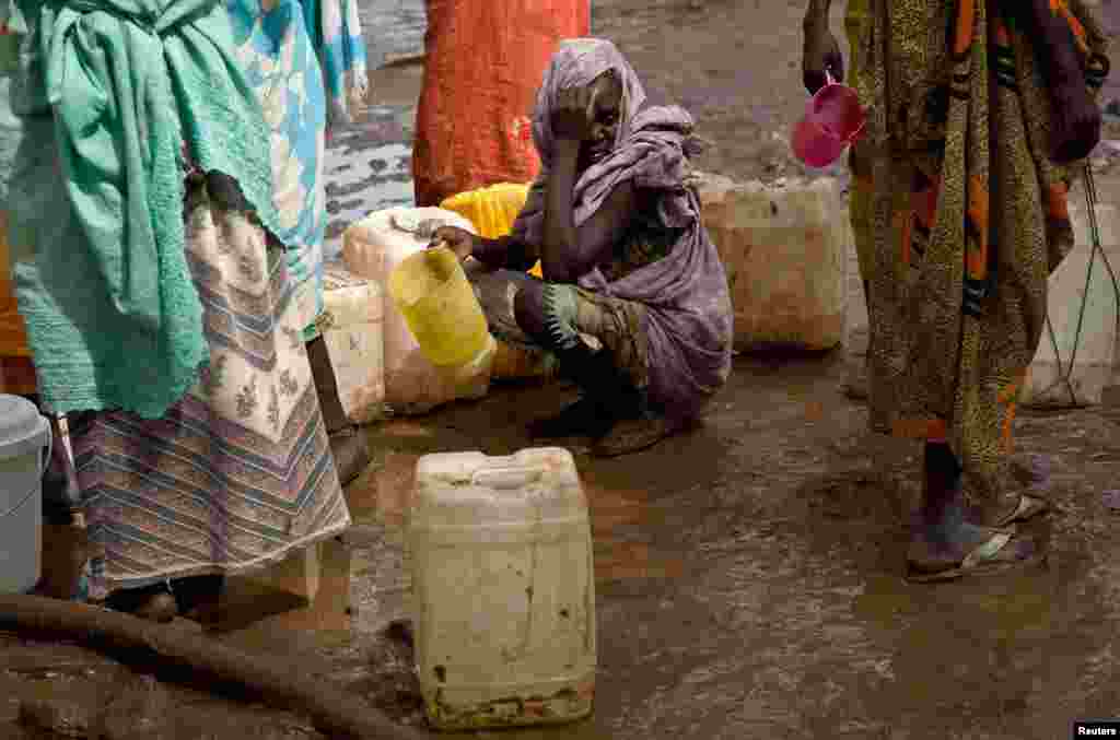 A woman waits in a queue to collect water at Yusuf Batil refugee camp, Upper Nile, South Sudan, July 4, 2012.