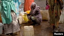 A woman waits in queue to collect water at Yusuf Batil refugee camp, Upper Nile, South Sudan, July 4, 2012.