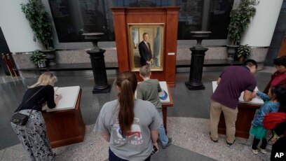 Visitantes à biblioteca e Museu George H. W. Bush no Texas assinam o livro de condolências.