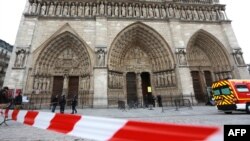 French policemen cordon off in front of Paris' Notre Dame Cathedral following the evacuation of the after a man shot himself dead in front of the altar, May 22, 2013.