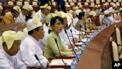 Burma's opposition leader Aung San Suu Kyi, third from left, takes a seat for a regular session of Parliament at Burma's Lower House in Naypyitaw, July 9, 2012.
