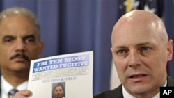 FBI Executive Assistant Director Shawn Henry (r) holds up a wanted poster during a news conference in Washington with Attorney General Eric Holder, March 9, 2011
