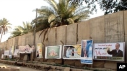 Campaign posters line a concrete blast wall in Baghdad ahead of Sunday's national elections, 06 Mar 2010