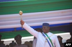 Le président de la Sierra Leone, Maada Bio, soulève le sceptre du pouvoir lors de son investiture à Freetown le 12 mai 2018.