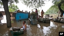 A man drags a trunk to higher ground after floodwaters inundated homes along the banks of the Yamuna River, in New Delhi, India, June 19, 2013.