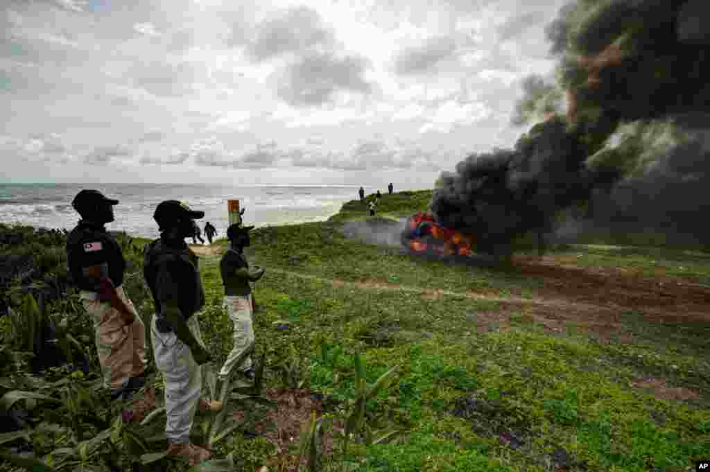 Liberia Drug Enforcement Agency officials look on as a recently seized stash of marijuana is burned in Paynseville, on the outskirts of Monrovia.