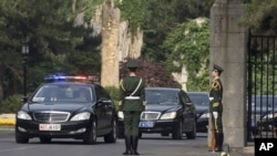 A car, second from left, believed to be carrying North Korean envoy Choe Ryong Hae, is escorted by a convoy of cars as it leaves Beijing's Diaoyutai State Guesthouse, May 24, 2013. 