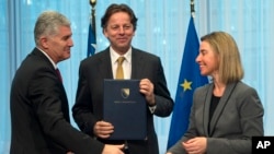 Chairman of the Presidency of Bosnia and Herzegovina Dragan Covic, left, Dutch Foreign Minister Bert Koenders, center, and European Union High Representative Federica Mogherini participate in a handover ceremony of the EU membership Application with Bosnia Herzegovina at the EU Council building in Brussels on Monday, Feb. 15, 2016. 