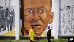 FILE - The Gyalwang Drukpa, bottom center, the Buddhist leader of South Asia, prays in front of a mural depicting Freddie Gray alongside the Rev. Jamal Bryant during a walking tour with other faith and community leaders, Thursday, May 7, 2015.