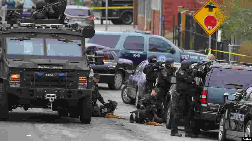 Police officers take position during a search for the Boston Marathon bombing suspects in Watertown, Massachusetts April 19, 2013.