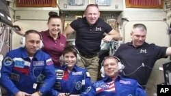 FILE - Expedition 42 crew members aboard the International Space Station in the Zvezda service module.