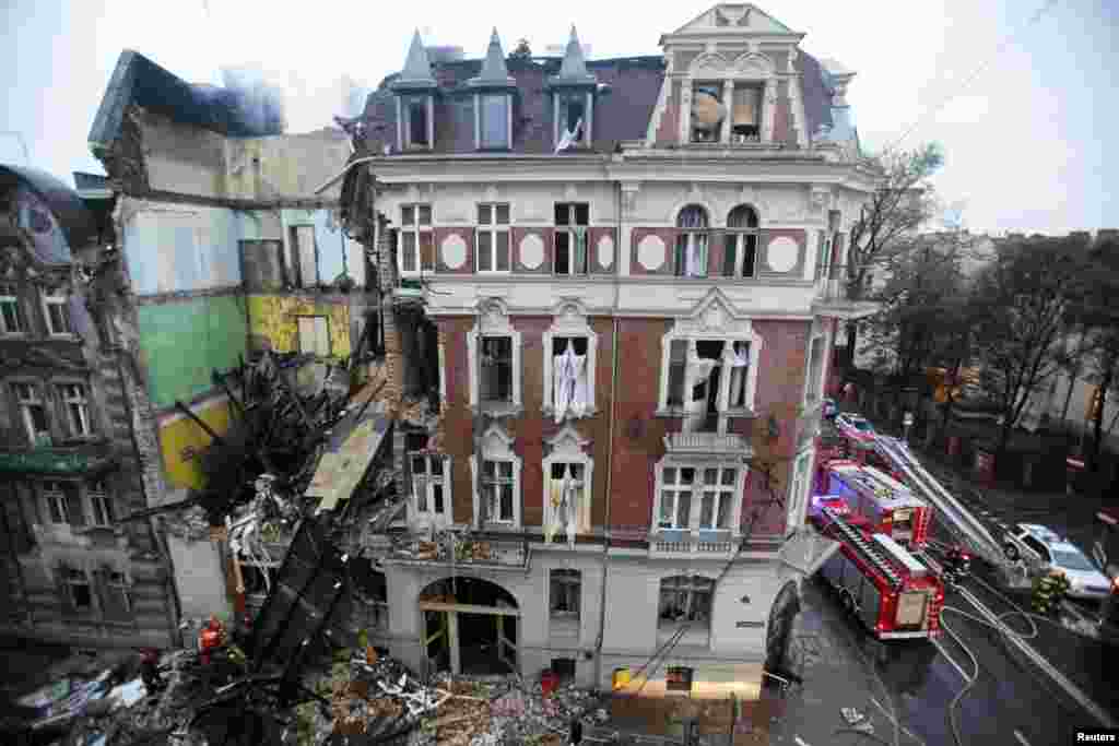 Fire fighters are seen at the scene of a gas explosion at an apartment building in the center of Katowice, Poland. Five people were injured after the morning gas explosion, which caused part of the building to collapse. 