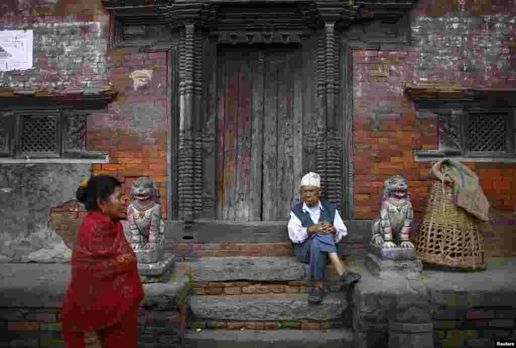A man sits at the doorway of a temple along the streets in the ancient city of Bhaktapur, near Nepal&#39;s capital Kathmandu. 