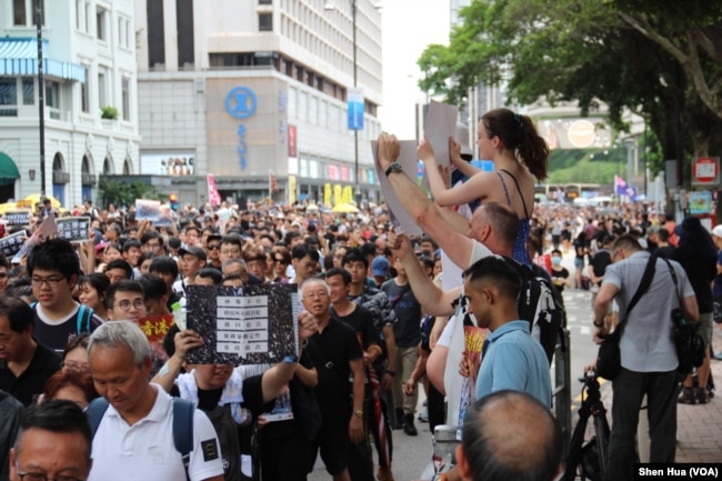 2019年7月7日，有外国人为抗议者游行助兴 （美国之音记者申华拍摄）