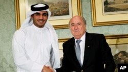 L'ex-président de la FIFA Sepp Blatter, à droite, serre la main à Sheik Mohammed bin Hamad al-Thani, président du comité d'organisation de la coupe du monde Qatar 2022, Doha, 9 novembre 2013.