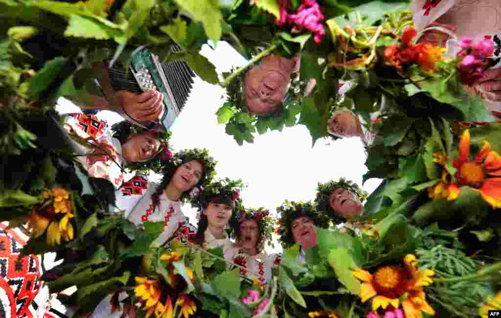 Belarussian women wearing traditional clothes and holding flowers sing in the village of Plastok, some 175 kms south of Minsk as part of festivities surrounding the Orthodox "Trinity's Day" holiday.